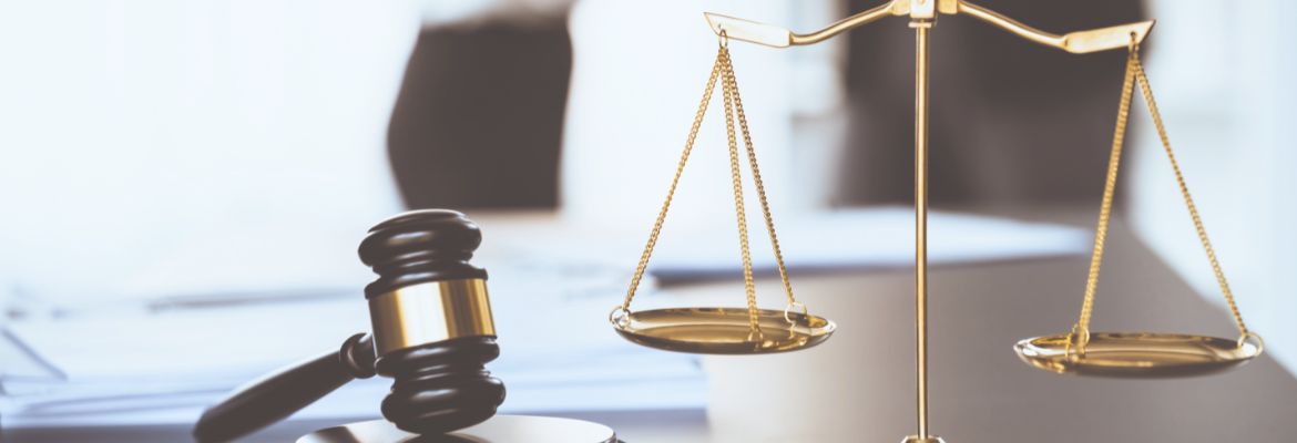 Balanced scale of justice and gavel hammer in focus on blurred background