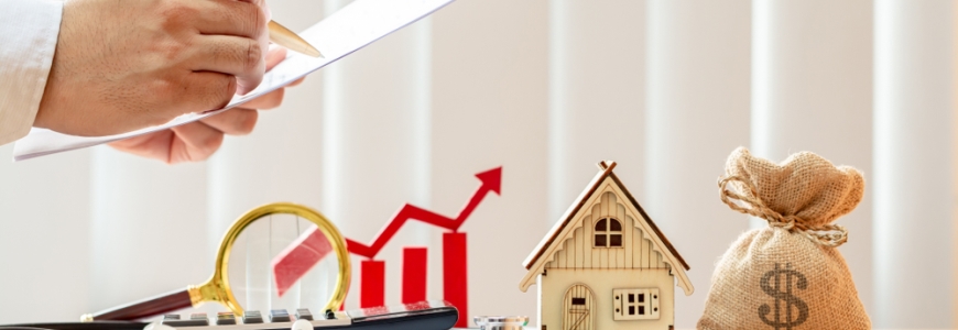 Money bag, toy house, magnifying class and a wooden graph showing increase in a row