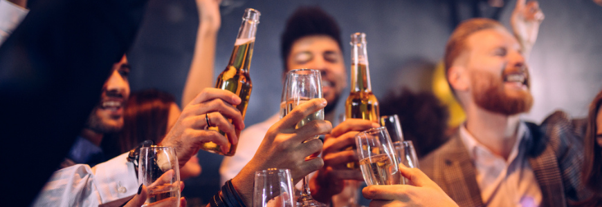 Group of friends cheering with champagne and beer