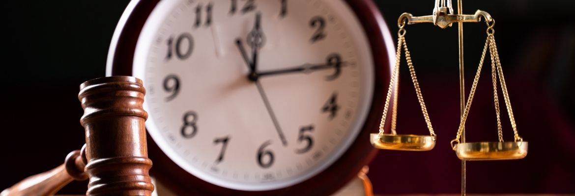 table with judge hammer, balance scale and wall clock