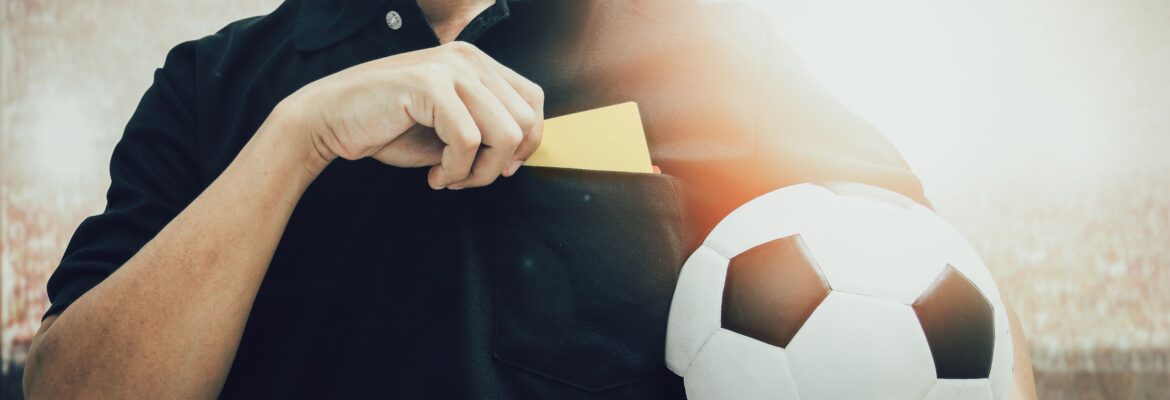Closeup of soccer referee hand holding yellow card punishment in the stadium during match close up