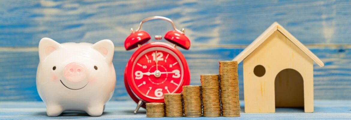 Piggy bank and stack gold coin with growing interest and home model and alarm clock with time in the office, Loan or saving money for buy house and asset and business investment in the future concept.
